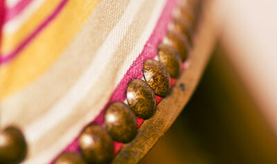 closeup of upholstery tacks on an old traditional wooden chair