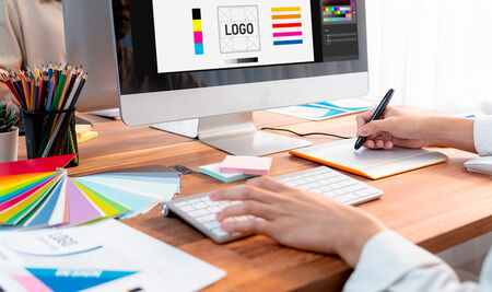 Graphic designer works on computer laptop with digital pen. Scrutinize