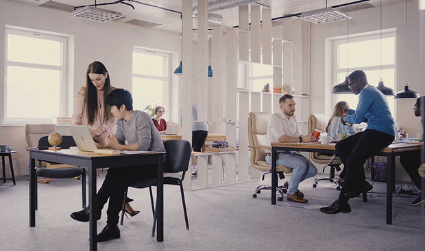 Multiethnic team working in modern trendy office. Happy young smiling creative millennials work in light coworking 4K.