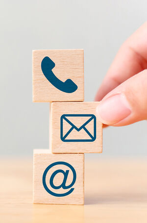 Hand putting wooden block cube symbol telephone, email, address. Website page contact us or e-mail marketing concept
