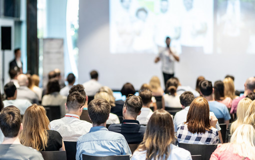 Male business speaker giving a talk at business conference event.