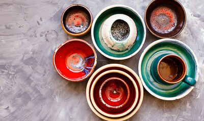 Ceramic tableware on grey background from above